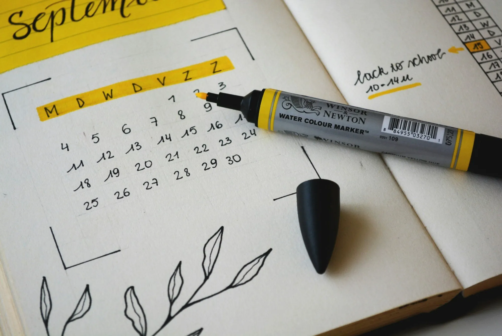 Calendrier manuscrit annoté au feutre jaune, ouvert sur le mois de septembre