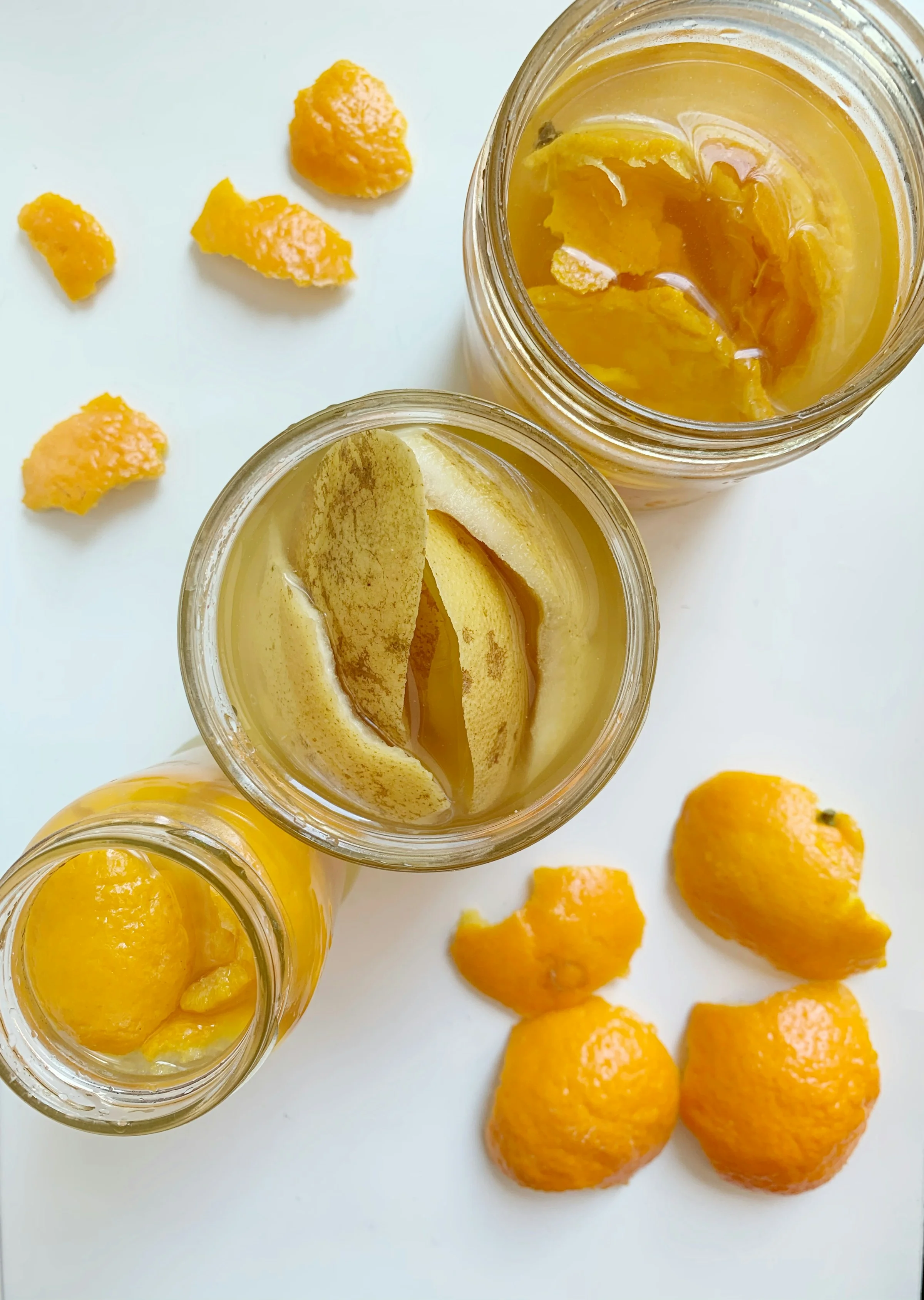 Bocaux en verre avec citrons confits et quartiers dorés sur fond blanc