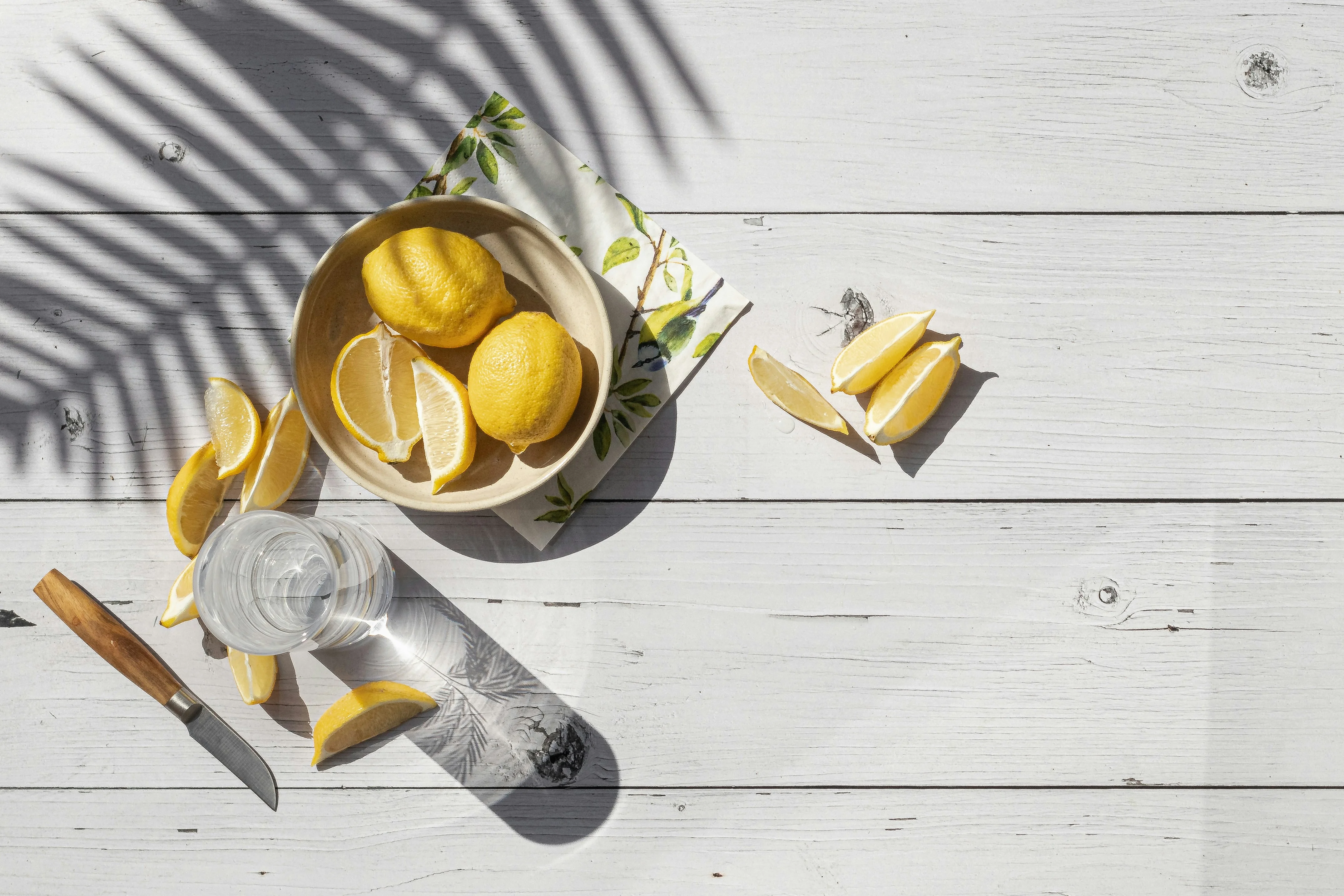 Citrons coupés, quartiers et couteau sur bois clair — conserver un citron entamé
