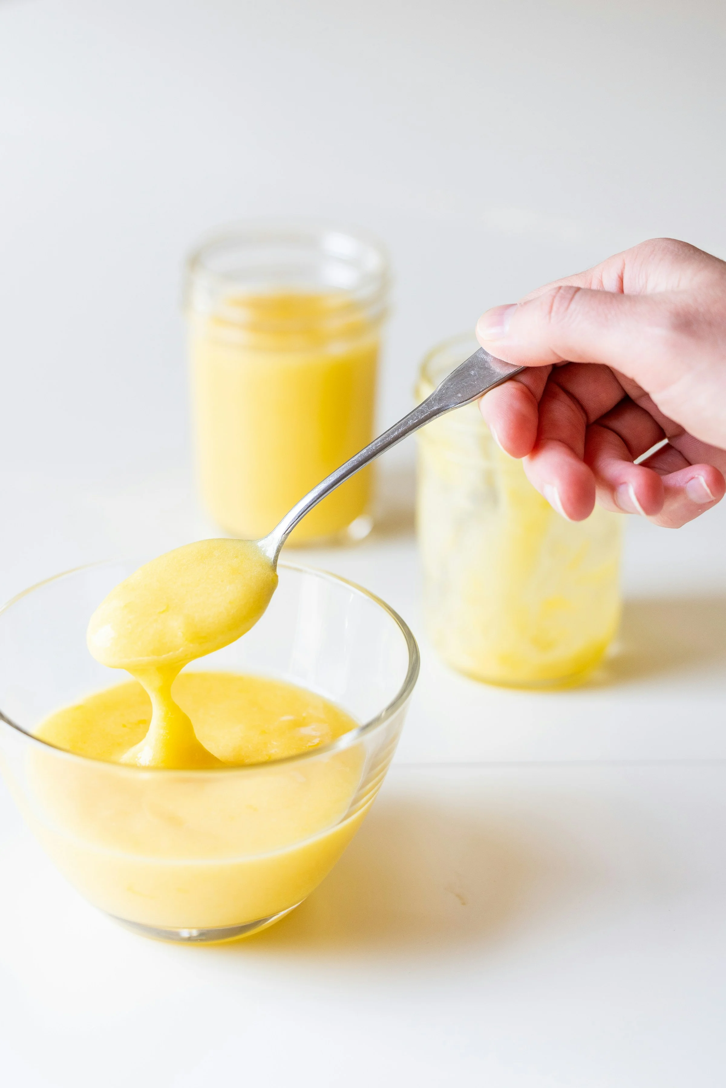 Crème de citron jaune onctueuse dans un bol en verre avec une cuillère