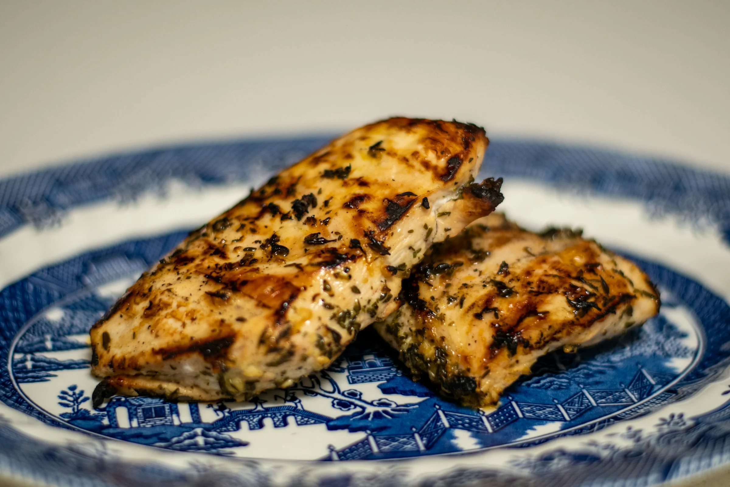 Blancs de poulet grillés et marinés aux herbes sur une assiette bleue