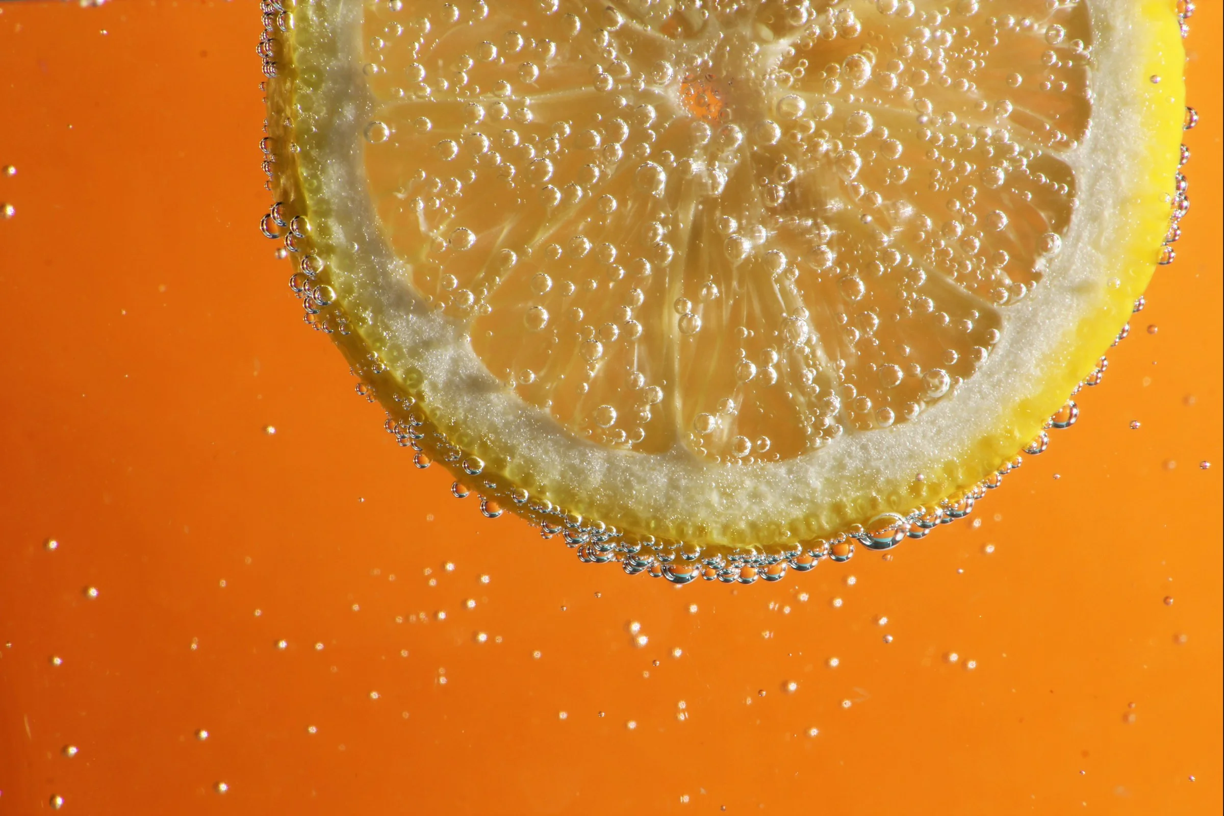Citron tranché en macro avec gouttelettes acides