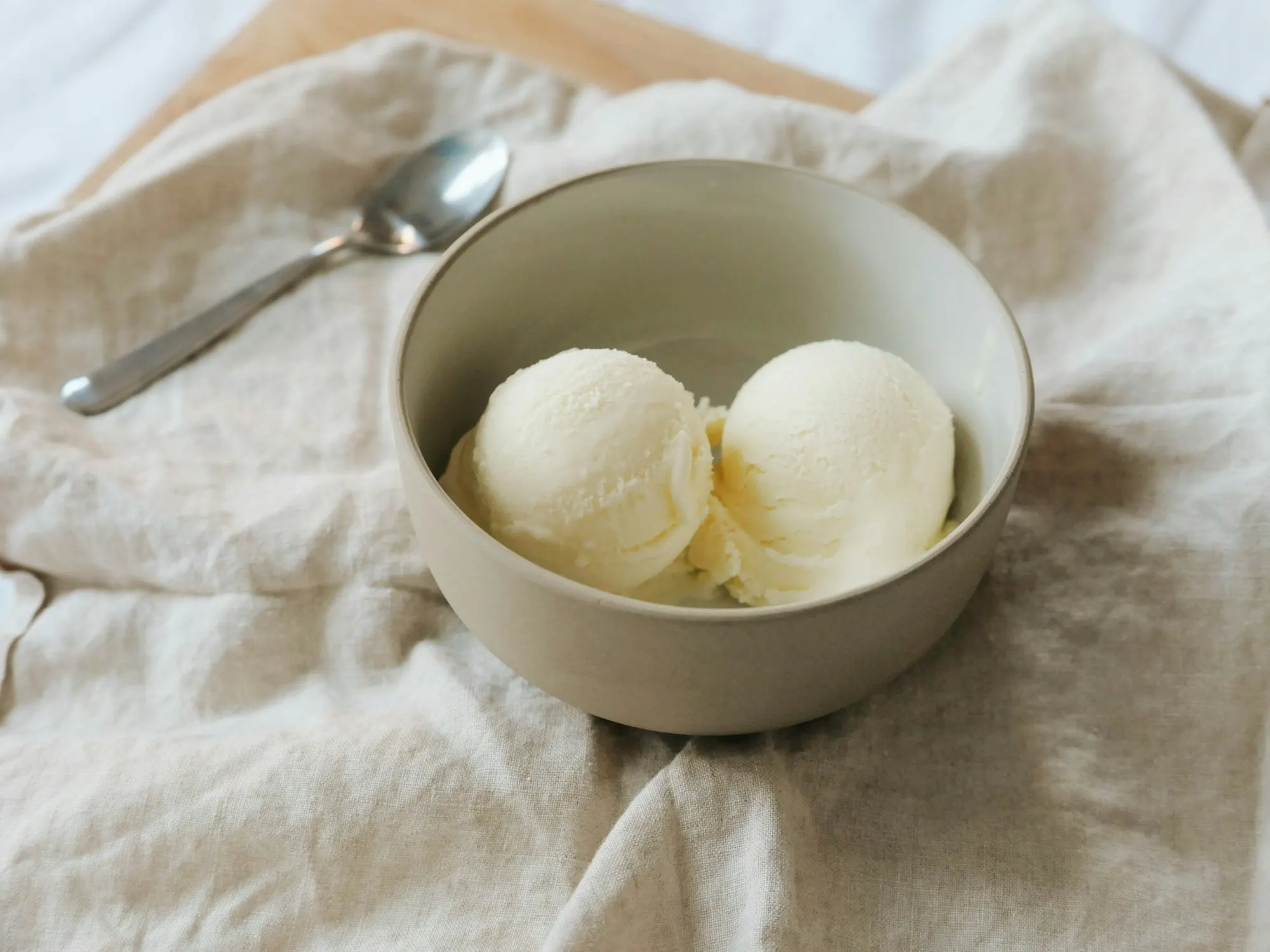 Deux boules de sorbet au citron pâle dans un bol en céramique sur lin