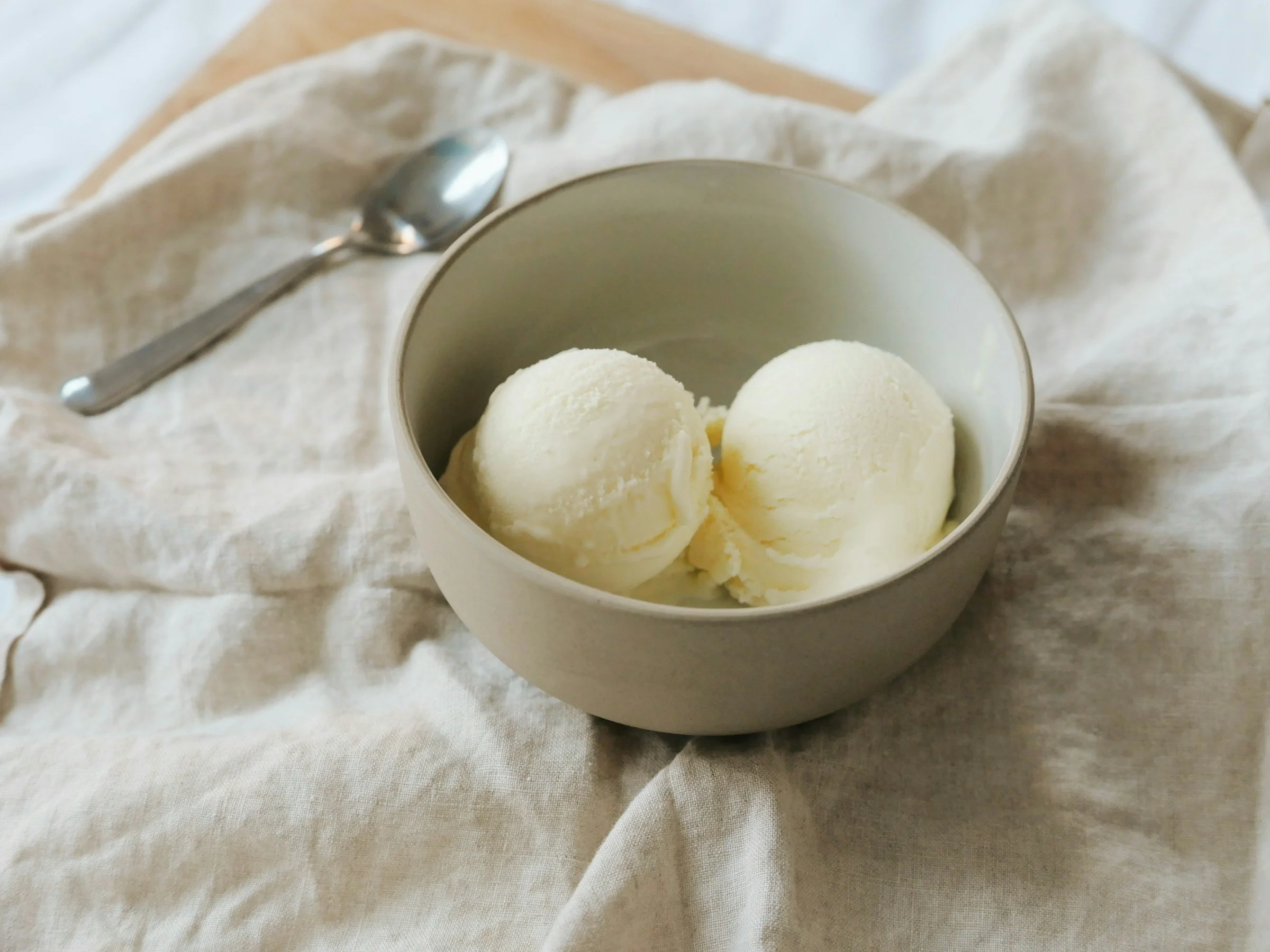 Deux boules de sorbet au citron pâle dans un bol en céramique sur lin