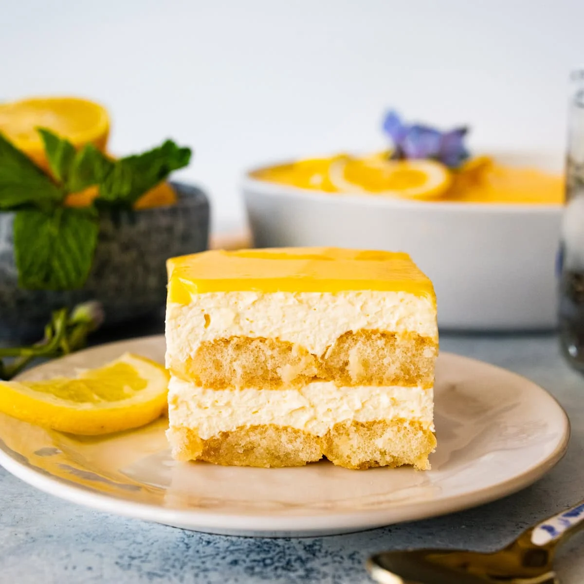 Part de tiramisu au citron en couches, nappée de crème de citron et menthe