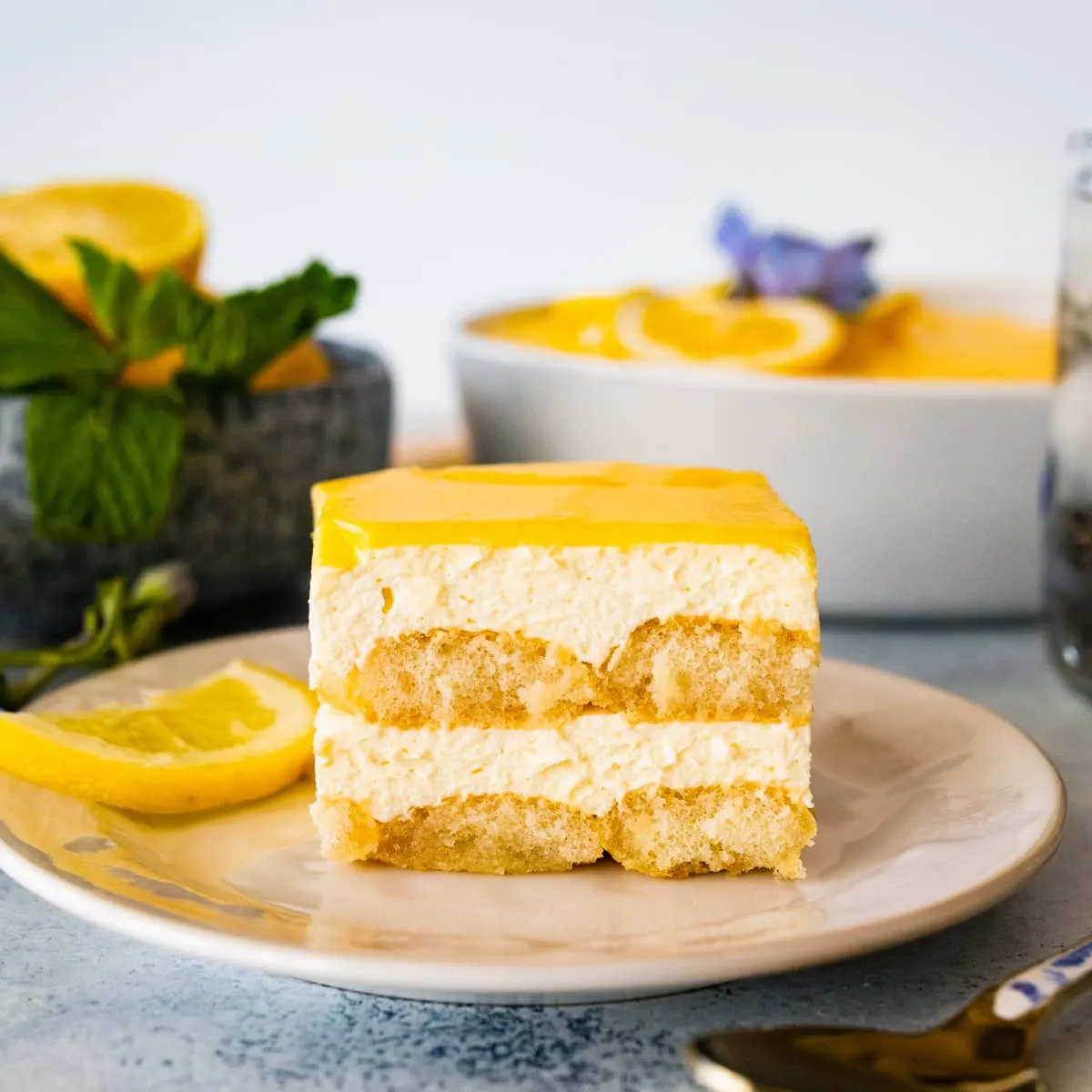 Part de tiramisu au citron en couches, nappée de crème de citron et menthe