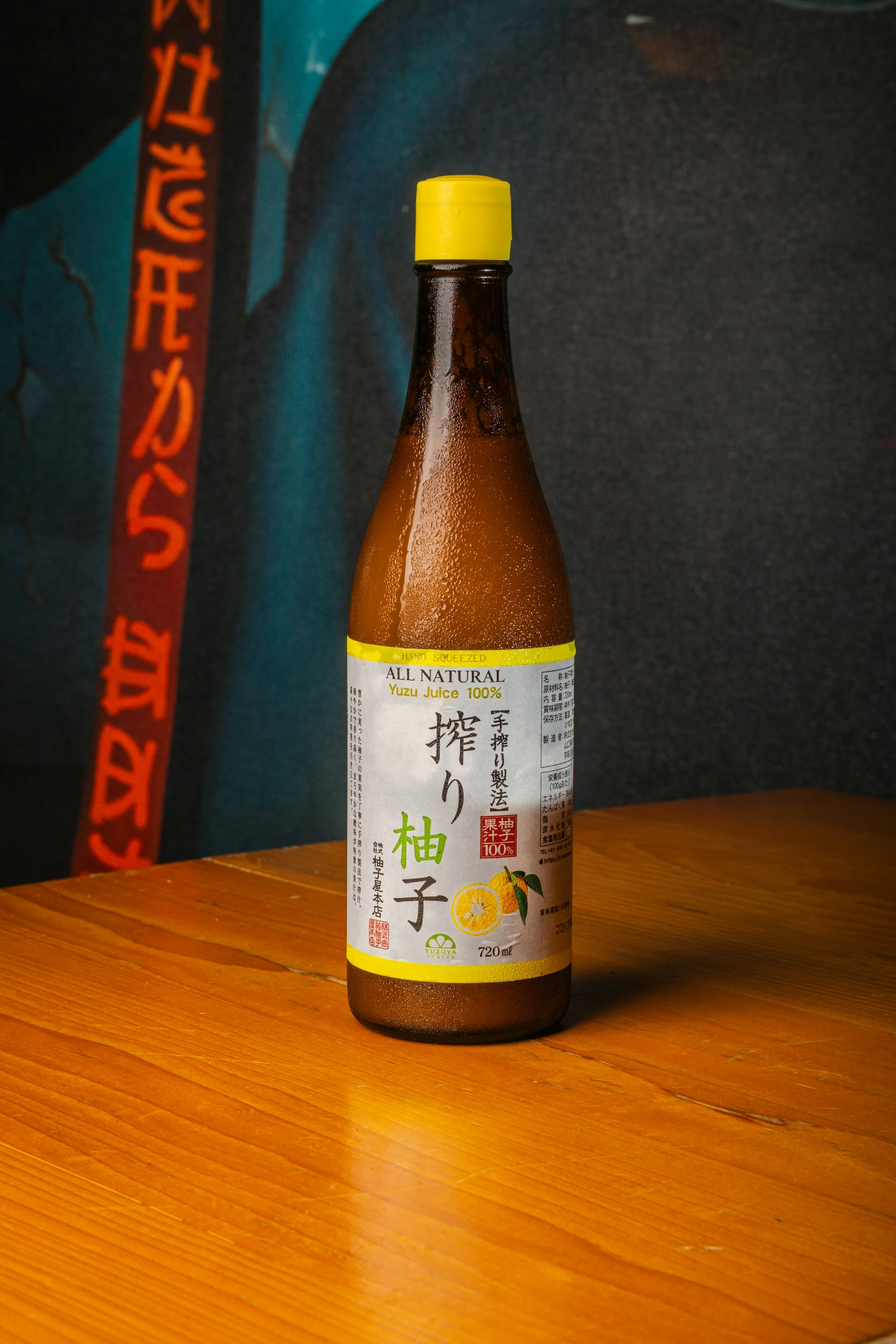 Bouteille de jus de yuzu 100 % naturel sur table en bois