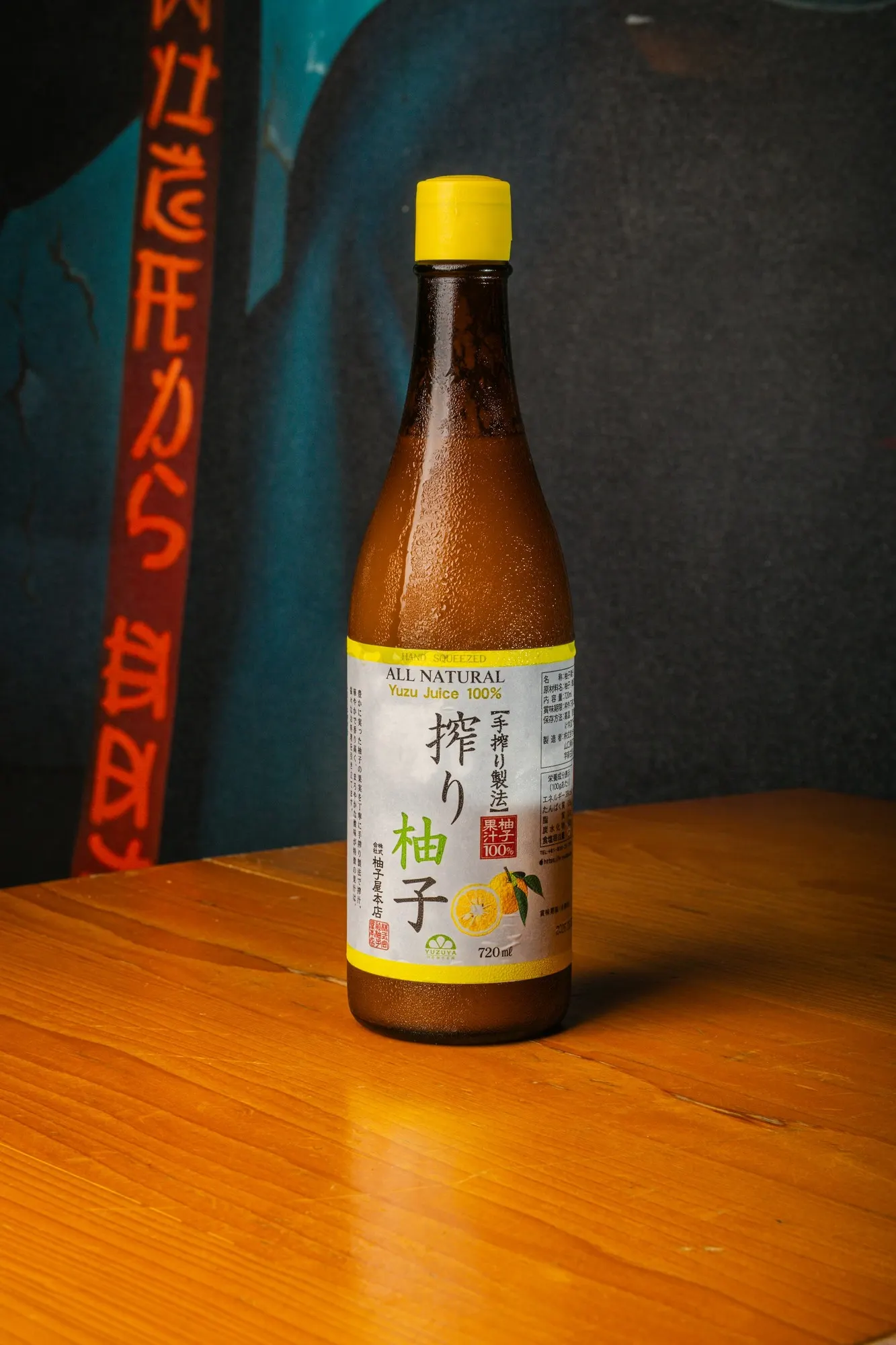 Bouteille de jus de yuzu 100 % naturel sur table en bois